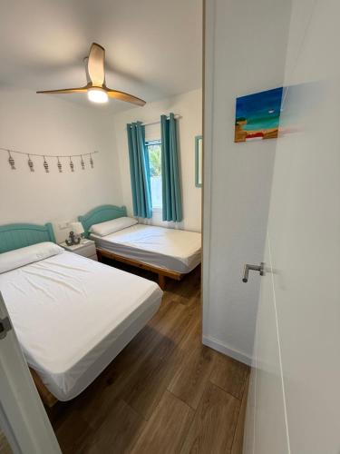 a bedroom with two beds and a window at Ca la Marta apartamento con piscina y jardín a 150m de la playa in Arenal d'en Castell