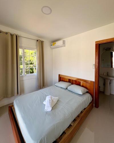 a bedroom with a bed with two pillows and a window at Villa Rio Grande in Santa Catalina
