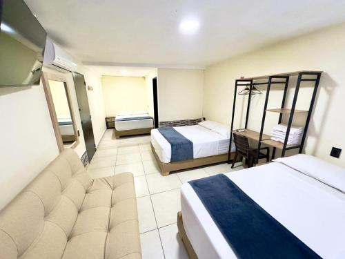 a hotel room with two beds and a desk at Hotel Estadio 80 in Medellín