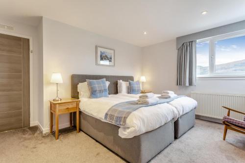 a bedroom with a large bed and a window at 3 Bed in Ullapool oc-s33063 in Ullapool