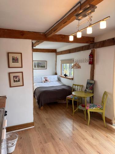 a bedroom with a bed and a table and chairs at Vinnies hideaway in Morpeth