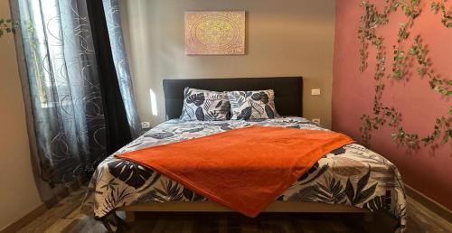a bedroom with a bed with an orange blanket at Brise Douce in Perpignan