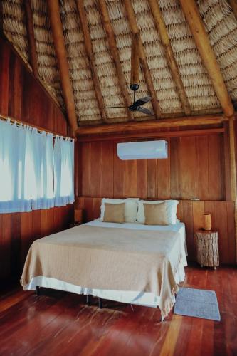 a bedroom with a bed in a wooden room at Pousada Jardim do vento in Icaraí