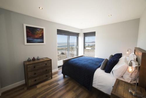 a bedroom with a bed and a view of the ocean at Taigh Rona in Tarbert