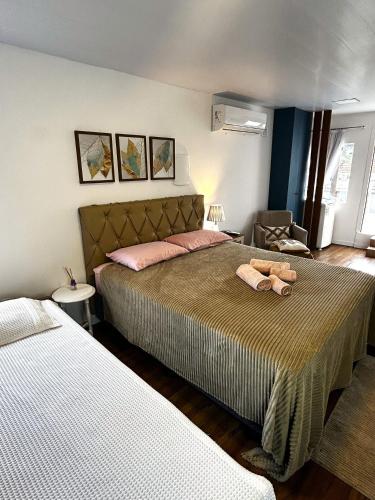 a bedroom with two beds and a chair at RCM Vilas - Casa Descolada in Joinville