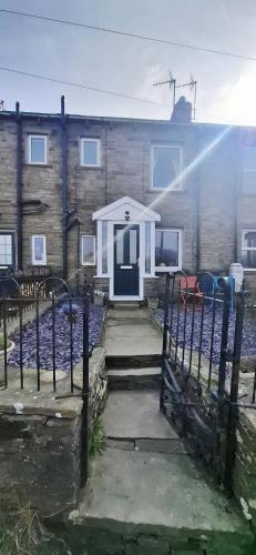 a house with a white door and a fence at Lancaster Cottage in Hawes