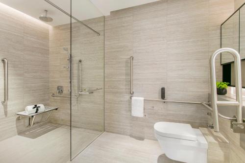 a bathroom with a glass shower and a toilet at Ascott Orchard Singapore in Singapore