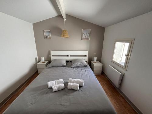 a bedroom with a large bed with two towels at Maison avec plage à pied in Saint-Georges-dʼOléron