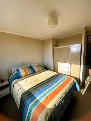 a bedroom with a bed with a colorful comforter at CHEZ GERARDo ! in La Serena