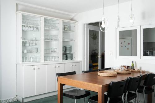a dining room with white cabinets and a wooden table at BaruHaus GRUPOS Rua Legio in León