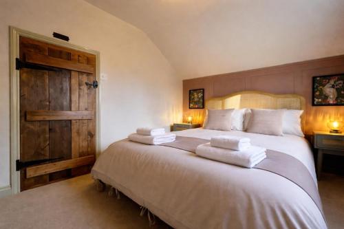 a bedroom with a large bed with towels on it at Daisy Cottage - Framlingham in Framlingham