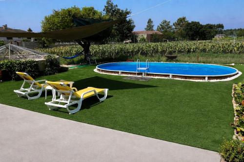 a yard with two chairs and a swimming pool at Casa da Tia in Poutena