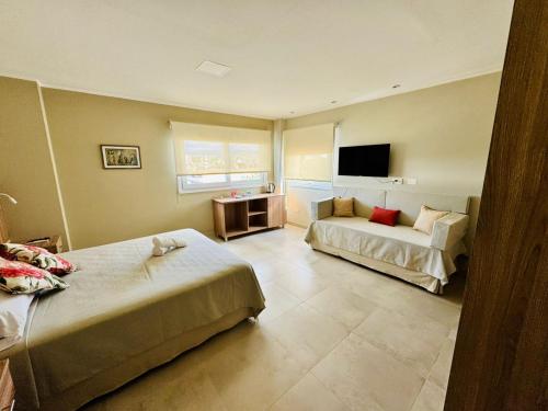 a hotel room with two beds and a television at Terra Alta Suites in Salta