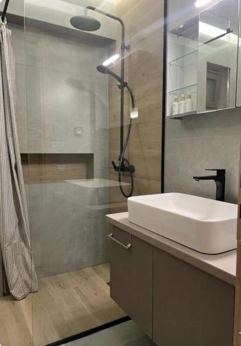 a bathroom with a sink and a shower at Anna's sea view apartment in Kánithos