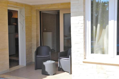 a patio with a chair and a window at X N Skiathos in Skiathos