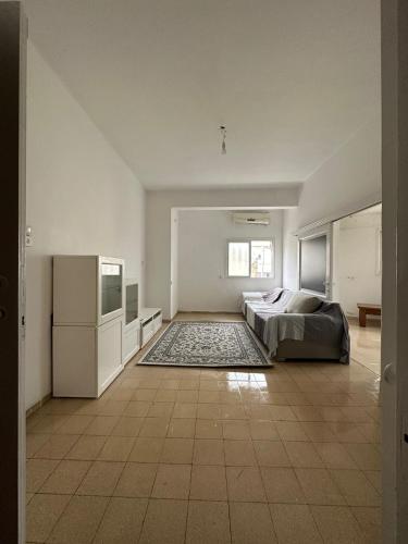a large white bedroom with a bed and a television at Cringe Boutique APT in Netanya