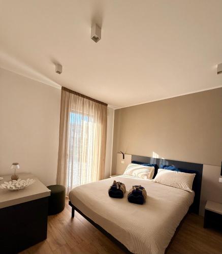 a bedroom with a bed with two bags on it at LA TERRAZZA APARTMENTS - Sand & Green Apartments - DeltadelPo in Porto Viro