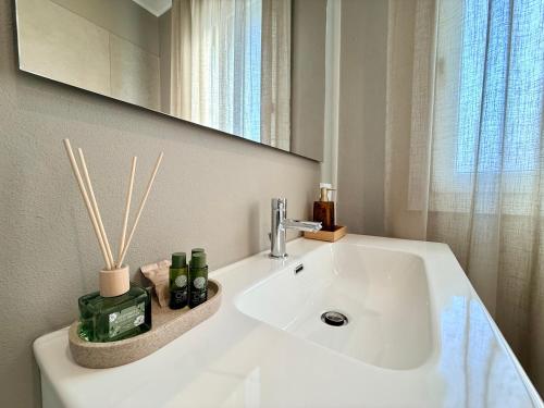 a bathroom with a white sink and a mirror at LA TERRAZZA APARTMENTS - Sand & Green Apartments - DeltadelPo in Porto Viro