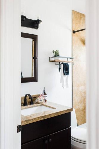 a bathroom with a sink and a toilet and a mirror at Little Chip Lake Arrowhead Cabin in Lake Arrowhead