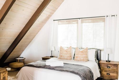 a bedroom with a bed with pillows and a window at Little Chip Lake Arrowhead Cabin in Lake Arrowhead