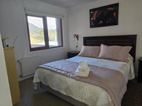 a bedroom with a bed with a candle on it at Akainij in Puerto Williams