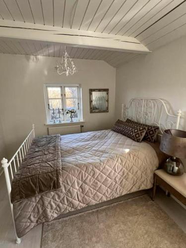 a bedroom with a large bed and a chandelier at Romantisk bondehus in Strandby
