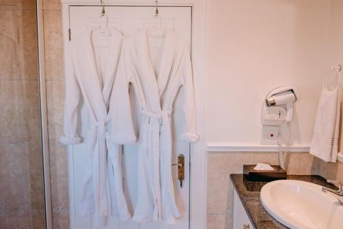 a bathroom with white clothes hanging on a door at La Vista Lodge in Plettenberg Bay