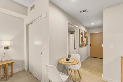 a dining room with a table and white chairs at Luxury Studio Steps from Bayfrontpark in Miami