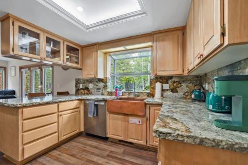 a kitchen with wooden cabinets and a window at River Rock House-Deck-BBQ-Forest Trails & Views! in South Lake Tahoe