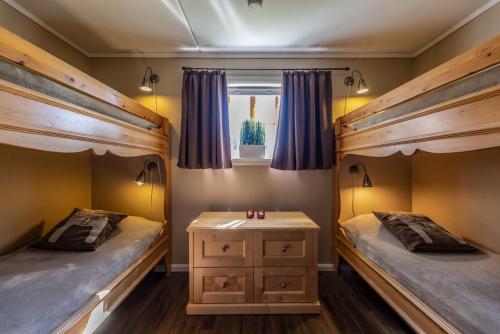 a bedroom with two bunk beds and a table at Gula Byn 410 in Sälen