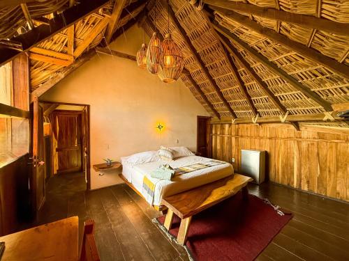 a bedroom with a bed and a wooden ceiling at Casa playa del Amor in San Pedro Pochutla