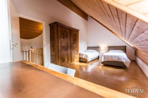 1 dormitorio con 2 camas en una habitación en Les Galeries Marval, en Neuchâtel