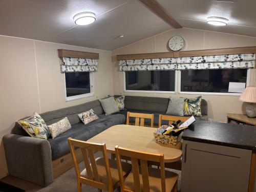 a living room with a couch and a table at Moonstone Costal Caravan Retreat in Saint Margaretʼs at Cliffe