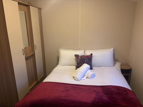 a bed with white sheets and pillows in a room at Moonstone Costal Caravan Retreat in Saint Margaretʼs at Cliffe