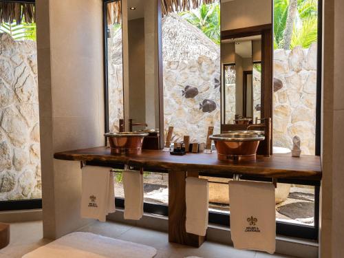 a bathroom with two sinks and a mirror at Le Tikehau by Pearl Resorts in Tikehau