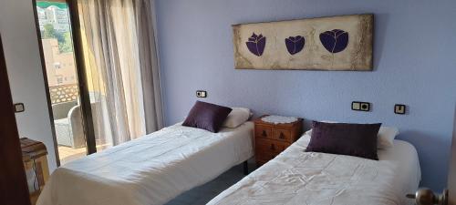 two beds in a room with blue walls and a window at Apartamento Les Fonts in Polop