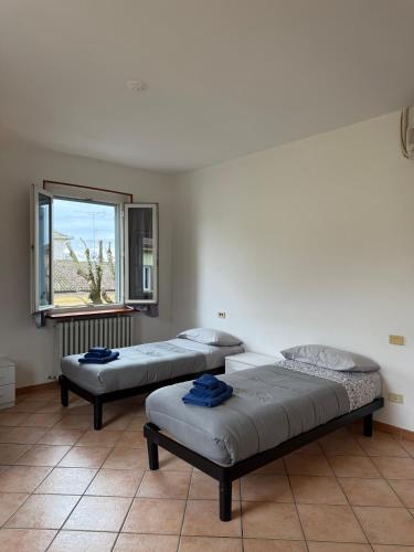 two beds in a room with a window at Double Spaces Apartaments in Tortona