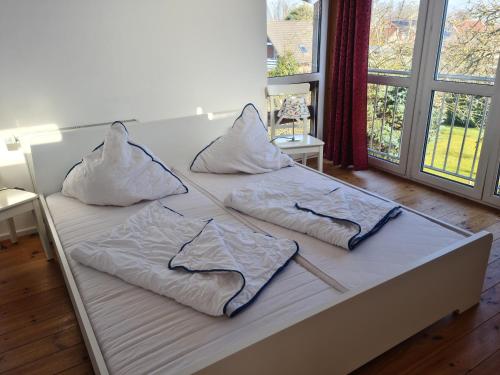 a bed with three pillows on top of it at Sonniges Sundchalet in Stralsund