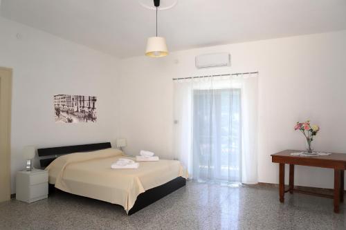 a bedroom with a bed and a table and a window at Gragnano in in Gragnano