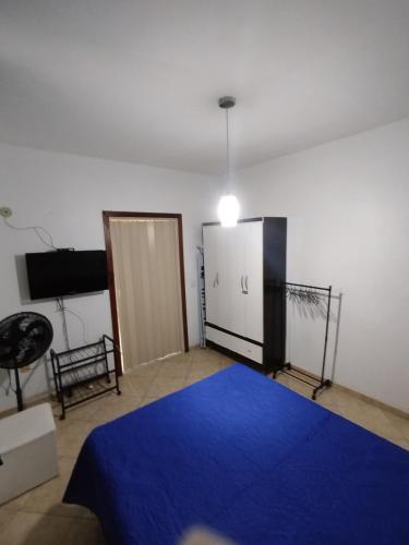 a bedroom with a blue bed and a sliding door at Condomínio Pousada Amarela 100 metros da Praia in Iguaba Grande