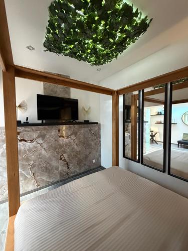a bedroom with a bed and a stone wall at Charnel - Suite Bali in Liège