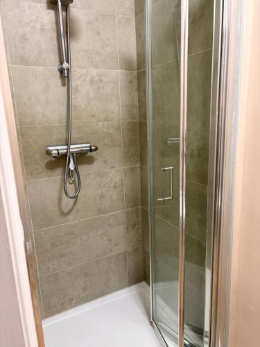 a shower with a glass door in a bathroom at The willow tree inn in Pilsley