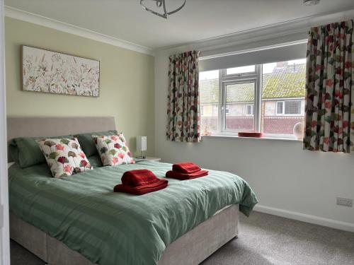 a bedroom with a bed with two red hats on it at Palm Tree House in Filey