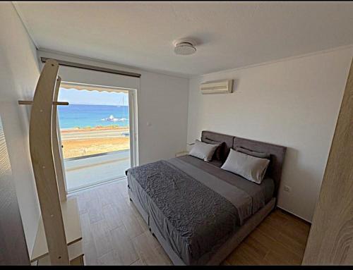 a bedroom with a bed with a view of the ocean at Saroné Villa in Anavyssos