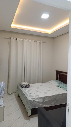 a bedroom with a bed and a white curtain at SSP Ubajara in Ubajara