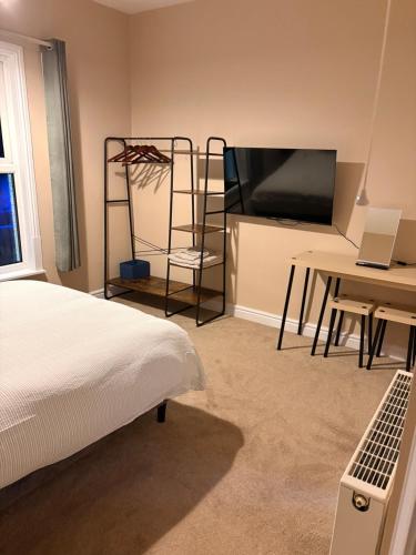 a bedroom with a bed and a desk and a television at The willow tree inn in Pilsley