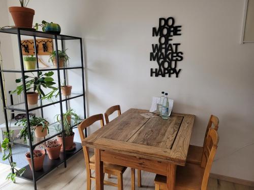 a wooden table and chairs in a room with plants at elfA-partment in Schwanstetten