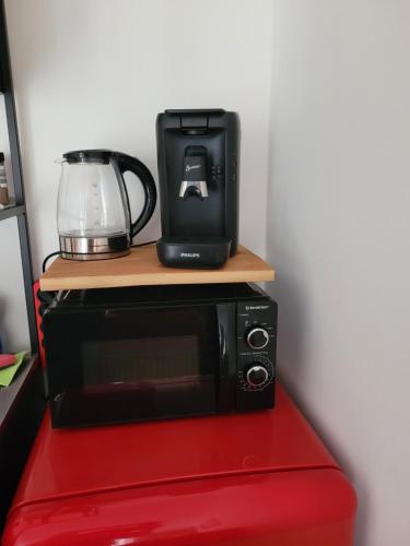 a black microwave sitting on top of a red table at elfA-partment in Schwanstetten