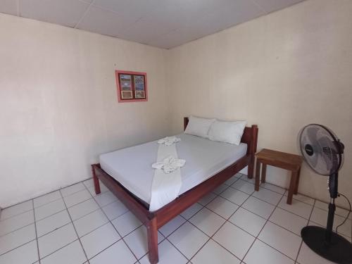 a bedroom with a bed and a fan in it at Guest House Nena in Moyogalpa