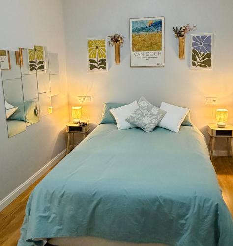 a bedroom with a large blue bed with two lamps at Apto Tramontana 98 in El Puerto de Santa María